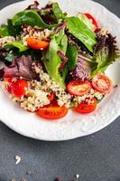 salad quinoa, tomato, green lettuce mix healthy meal food snack on the table copy space food background rustic top view photo