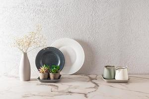 stylish kitchen background with contrasting dark and light dishes on a marble countertop. minimalist style in the design of the kitchen space. photo