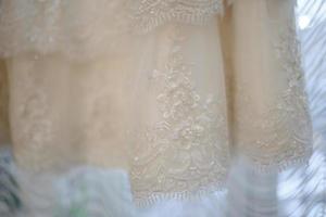 Part of an ivory wedding dress. French lace on the bride's dress with beads photo