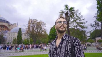 joven hombre caminando alrededor hagia Sofía. joven hombre visitando el históricamente significativo hagia Sofía en Estanbul. video