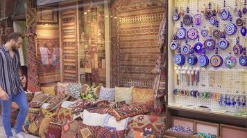 Handcrafted items. Young man looking at handmade woven rugs and pillows. video