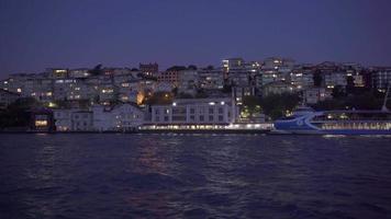 noche paisaje urbano ver de el ciudad en el línea costera desde el mar. video