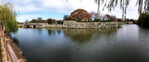Panorama view of Osaka castle canal on bright blue sky background. photo