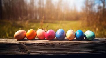 row of colorful easter eggs on wooden table and bokeh background, place for typography and logo. Rustic wooden table. Easter theme. . photo