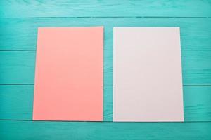 hojas de papel en blanco de color vacías sobre una mesa de madera de cerca foto