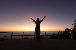 Silhouette of  Woman raising his hands in worship, woman praying for god, Christian Religion concept background. photo