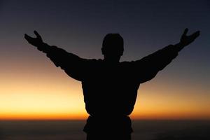 Silhouette of man hand praying spirituality and religion, female worship to god. Christianity religion concept. Religious people are humble to God. Christians have hope faith and faith in god. photo