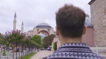 jong Mens zwervend in historisch plaatsen. de jong Mens wie is in hagia sophia is toeren Istanbul. video