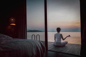 Woman doing yoga in nature outdoors at sunrise. Healthy lifestyle concept. photo