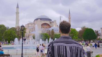 Jeune homme à la recherche à hagia sophie. le Jeune homme qui venu à visite hagia Sophia dans Istanbul est en train de regarder. video