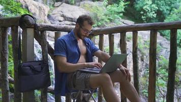 estresado oficina trabajador trabajando con ordenador portátil al aire libre. empresario carreras su negocio con ordenador portátil incluso en vacaciones. video
