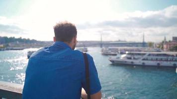 hombre gasto hora por el mar acecho el puesta de sol. joven hombre caminando alrededor Estanbul acecho el puesta de sol en el playa. video