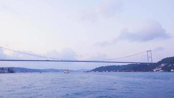 Cars and seagulls passing over the bridge in the Bosphorus. Vehicles pass over the bridge in the Bosphorus and seagulls fly over the sea. View from the sea. video