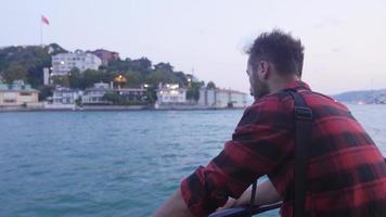 nervoso uomo è seduta su il traghetto. esausto. riflessivo e triste uomo seduta nervosamente su traghetto a sera crepuscolo. video