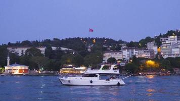 General view of boats and buildings in the Bosphorus. Historic building by the sea. The Turkish flag is waving and the boat is moving forward. video