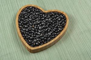 heart shaped black bean bowl on green tablecloth photo