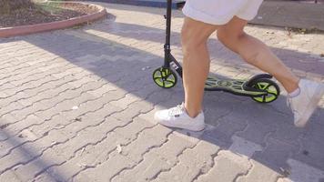 Masculin pieds équitation scooter dans le ville. équitation une scooter sur une bondé rue. video