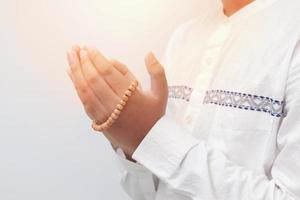 cerca arriba de masculino manos levantamiento y Orando con islámico rosario. religión concepto foto