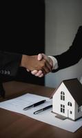 Real estate agent shaking hands with customer after signing contract for buying a house. photo