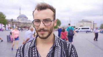 Man looking at camera in crowded street. Young man is on the street and looking at the camera moving around him. video