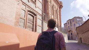 visitando y viendo histórico lugares. el joven hombre mira a antiguo edificios en el lado calles video