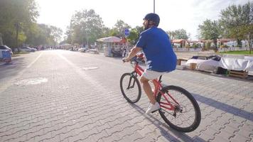 jovem homem equitação uma bicicleta em uma cidade rua. negócios, estilo de vida, transporte e pessoas conceito - ciclismo em cidade rua. video