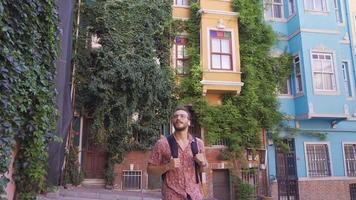 The traveler young man is walking around the historical streets. The young man is walking on the street with the historical Balat houses. video