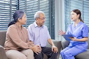 mayor asiático Pareja teniendo cita con médico para anual salud cheque arriba programa mientras el enfermero es explicando el sangre prueba resultado para sano envejecimiento y longevidad concepto foto