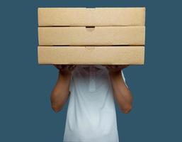 Man held up three brown cardboard boxes and covered his face photo