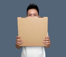 Man covering his face with cardboard box isolated on plain bacground photo