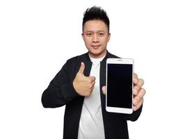 Casual man holding and showing smart phone screen with thumbs up gesture. photo