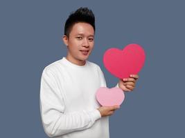 Handsome man holding and showing red and pink heart shape photo