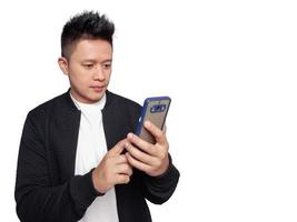 Handsome man holding and pointing at smartphone screen with calm facial expression. photo
