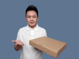 young man holding cardboard box and open palm. photo