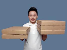 Man holding cardboard box in both hands isolated on plain background. photo