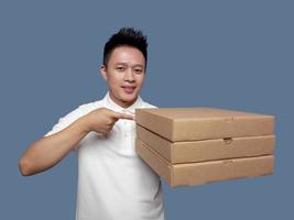 Man holding pizza box and pointing at it isolated on plain background photo