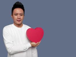 Man holding red heart shape isolated on plain background. photo