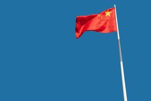 The national flags of China flutter against a blue sky. photo