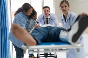 The doctor puts a splint on a patient with a leg. photo