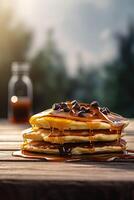 Syrup is poured down and chocolate chips are on top tall stack of golden pancakes layered on a plate with melted butter and syrup dripping down the sides of the stack. . photo