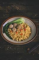 fried noodles in the plate with vegetables and meat photo