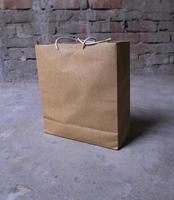 marrón papel bolso en cemento piso con ladrillo pared fondo, Clásico tono foto