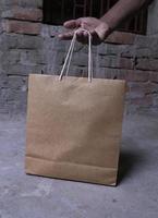 Closeup of a man holding a brown paper bag with copy space photo