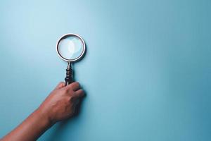 Magnifying glass on blue background. Top view. Flat lay. Copy space. Minimal creative concept. Blue background in pastel colours photo