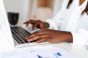 Close up image of woman hands typing on laptop computer keyboard and surfing the internet on office table, online, working, business and technology, internet network communication concept photo