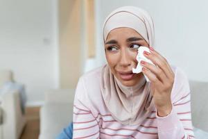 A sad Muslim woman in a hijab, crying. Close-up of a weeping Arab girl. photo