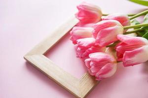 rosado tulipán flores son arreglado en un rosado antecedentes. el ver desde el arriba, plano poner. vacío espacio para el texto. primavera concepto. De las mujeres día. de la madre día. foto