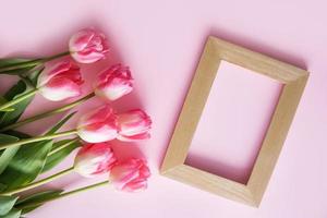 rosado tulipán flores son arreglado en un rosado antecedentes. el ver desde el arriba, plano poner. vacío espacio para el texto. primavera concepto. De las mujeres día. de la madre día. foto