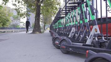 masculino empresario conducción eléctrico scooters en el ciudad. video