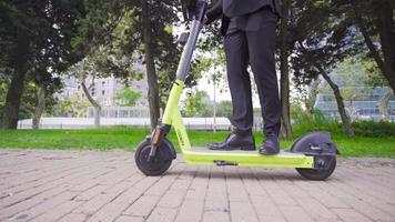 Respetuoso del medio ambiente eléctrico scooter. ambientalmente simpático empresario montando eléctrico scooter. video